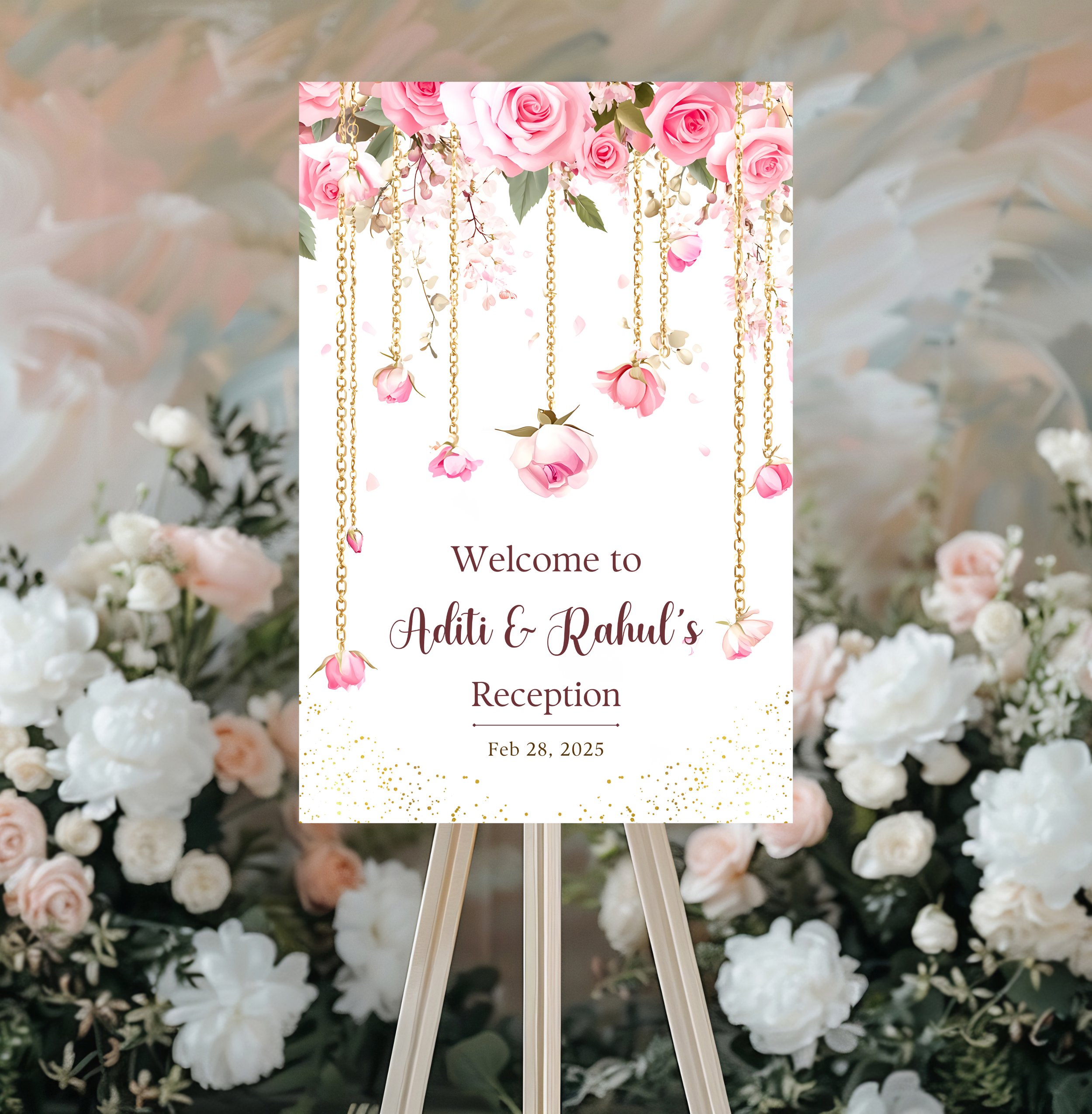 A white wedding welcome sign with pink flowers and gold chains hanging from the top. The sign reads 'Welcome to Aditi & Rahul's Reception Feb 28, 2025'.